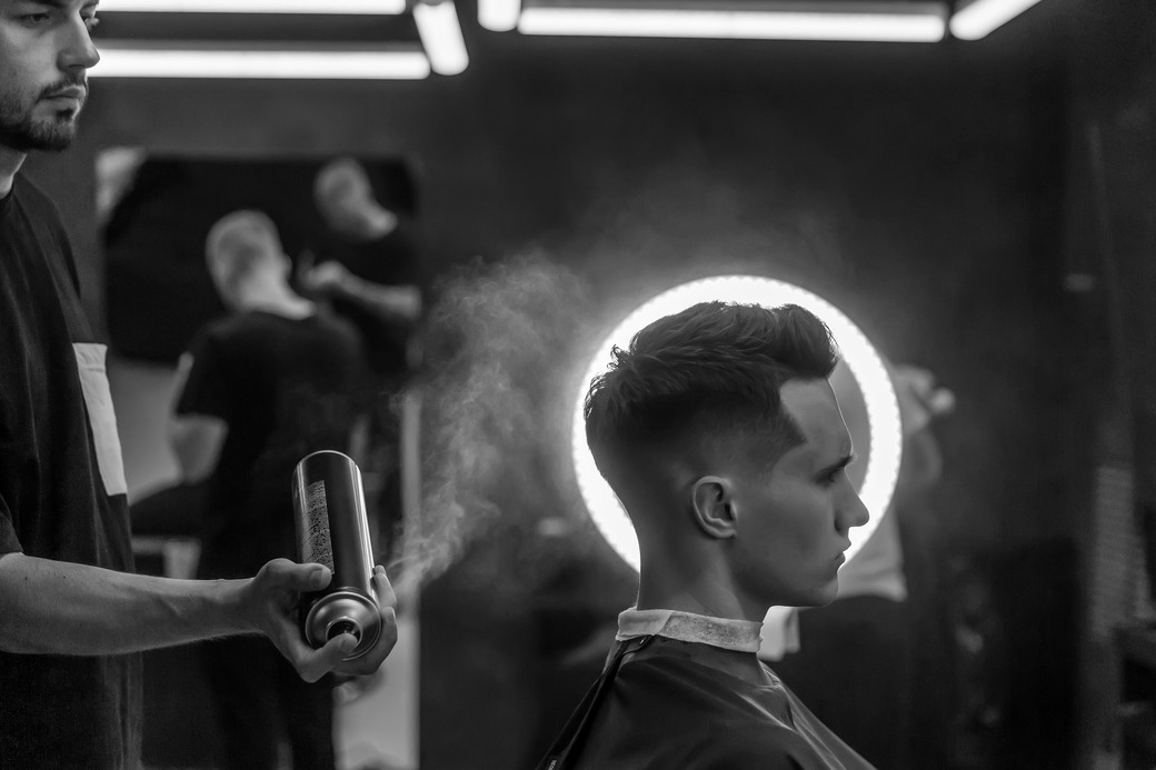 Stylist applying spray to men's haircut at The Crown Hair Studio
